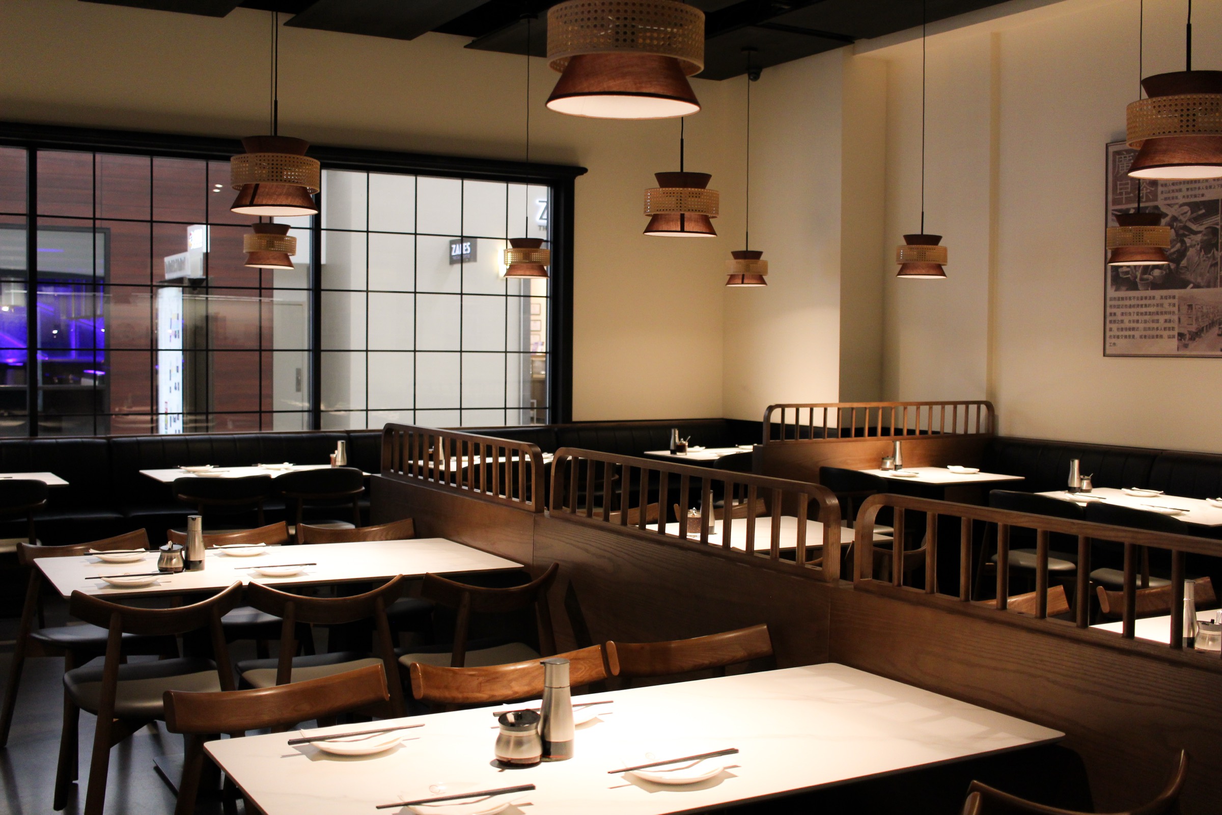 The dining room at Mr. Dim Sum, with wooden seating and rattan pendant lights
